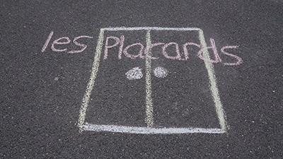 Dessin à la craie au sol d'un placard avec l'inscription "Les pacards"